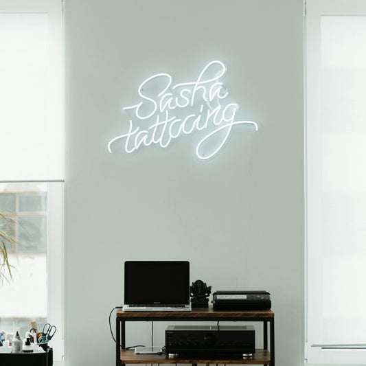 White LED Neon sign saying "Sash Tattooing" in a tattoo studio in the Gold Coast