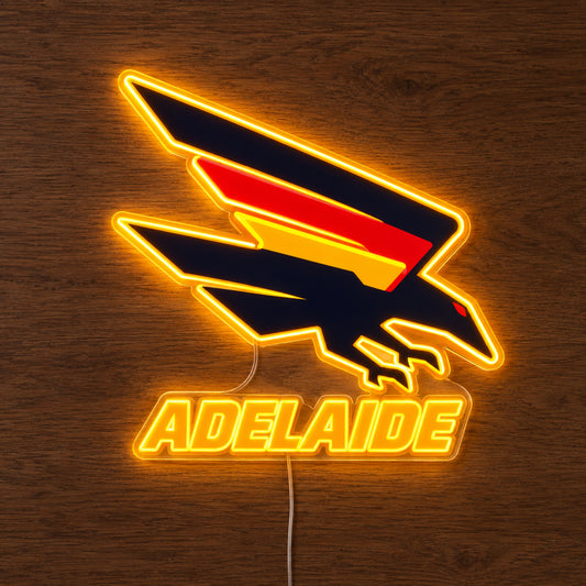 Adelaide Crows neon sign glowing brightly on a wooden surface in dim lighting