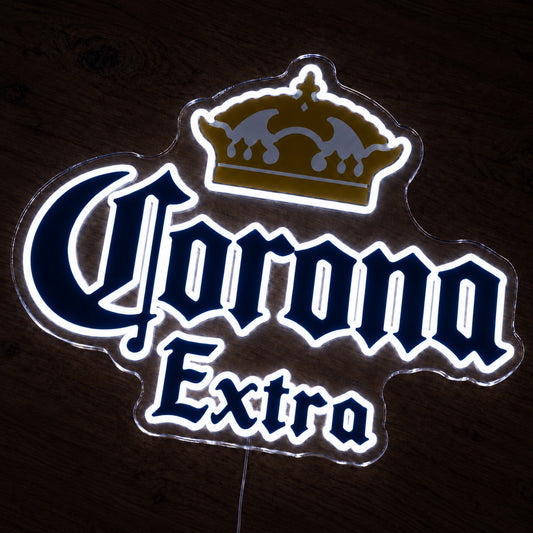 Corona Extra neon sign glowing brightly on a wooden surface in dim lighting