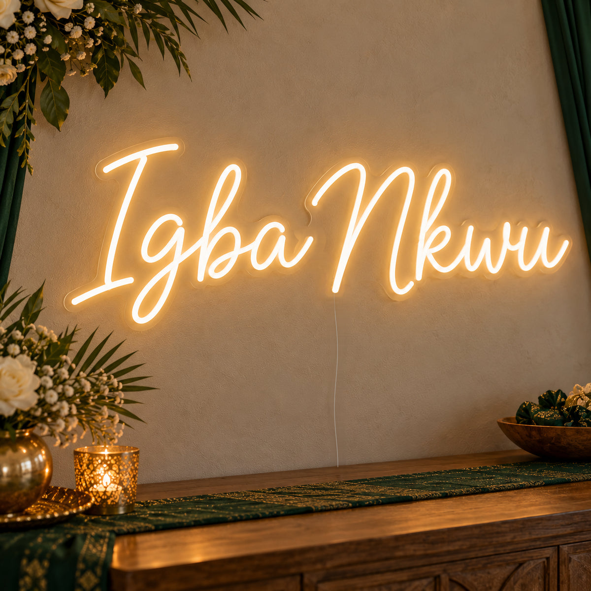 Igba Nkwu Neon Sign on clear cut-to-shape acrylic, illuminated on a wall in a styled celebration setting