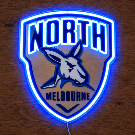 North Melbourne Kangaroos neon sign glowing brightly on a wooden surface in dim lighting