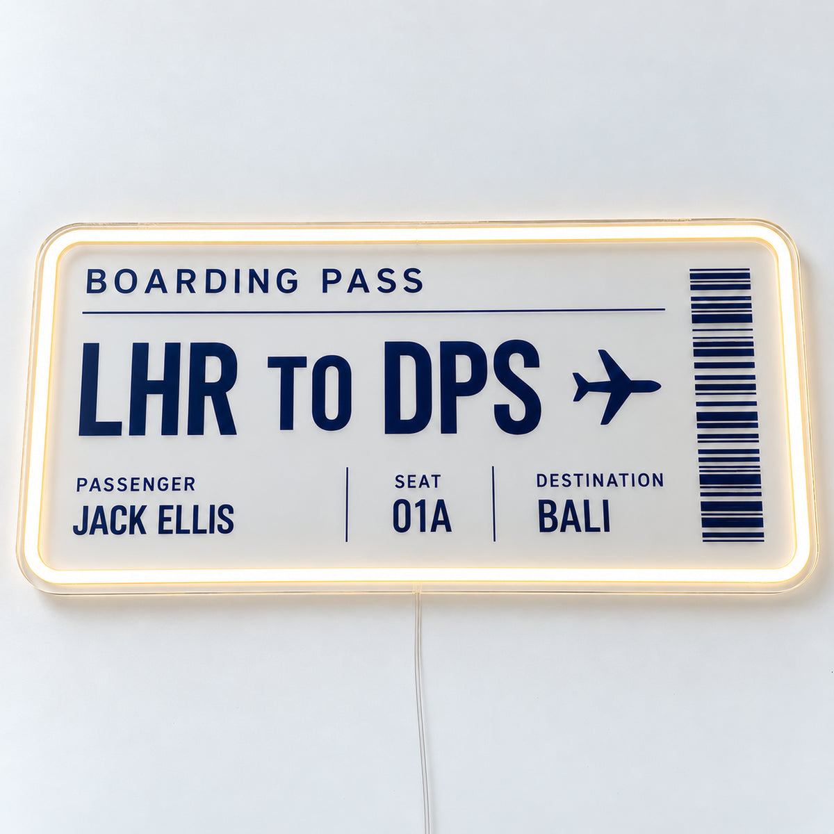 Personalised Boarding Pass Neon Sign, featuring a personalised boarding pass, shown with Jack Ellis and the LHR to DPS route, on a single clear acrylic backing displayed on a white surface.