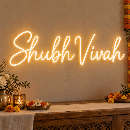 Shubh Vivah Neon Sign on clear cut-to-shape acrylic, illuminated on a wall in a styled celebration setting