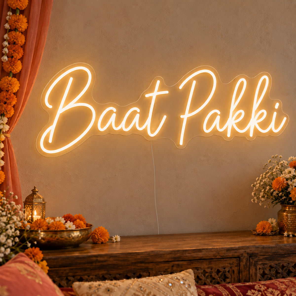 Baat Pakki Neon Sign on clear cut-to-shape acrylic, illuminated on a wall in a styled celebration setting