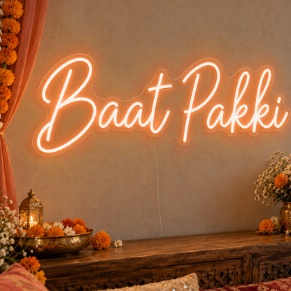 Baat Pakki Neon Sign in orange LED neon on clear acrylic, angled view