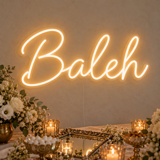 Baleh Neon Sign on clear cut-to-shape acrylic, illuminated on a wall in a styled celebration setting