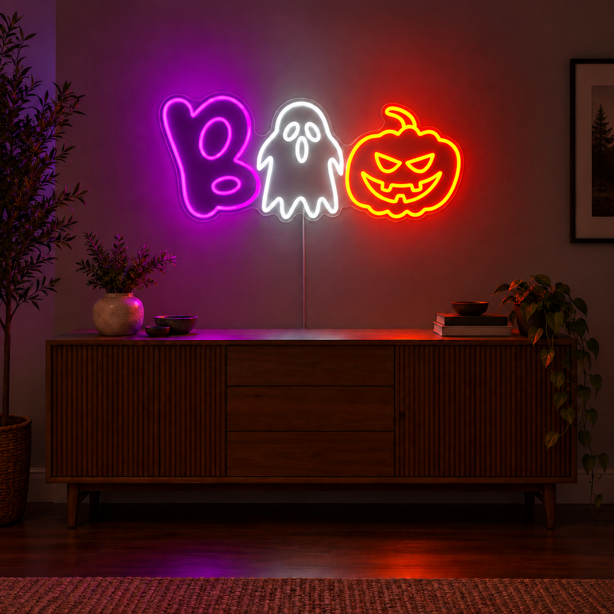 Boo Ghost and Pumpkin Neon Sign featuring a purple B, a white ghost and an orange pumpkin arranged to spell Boo, displayed on a dark wall above a wooden sideboard.