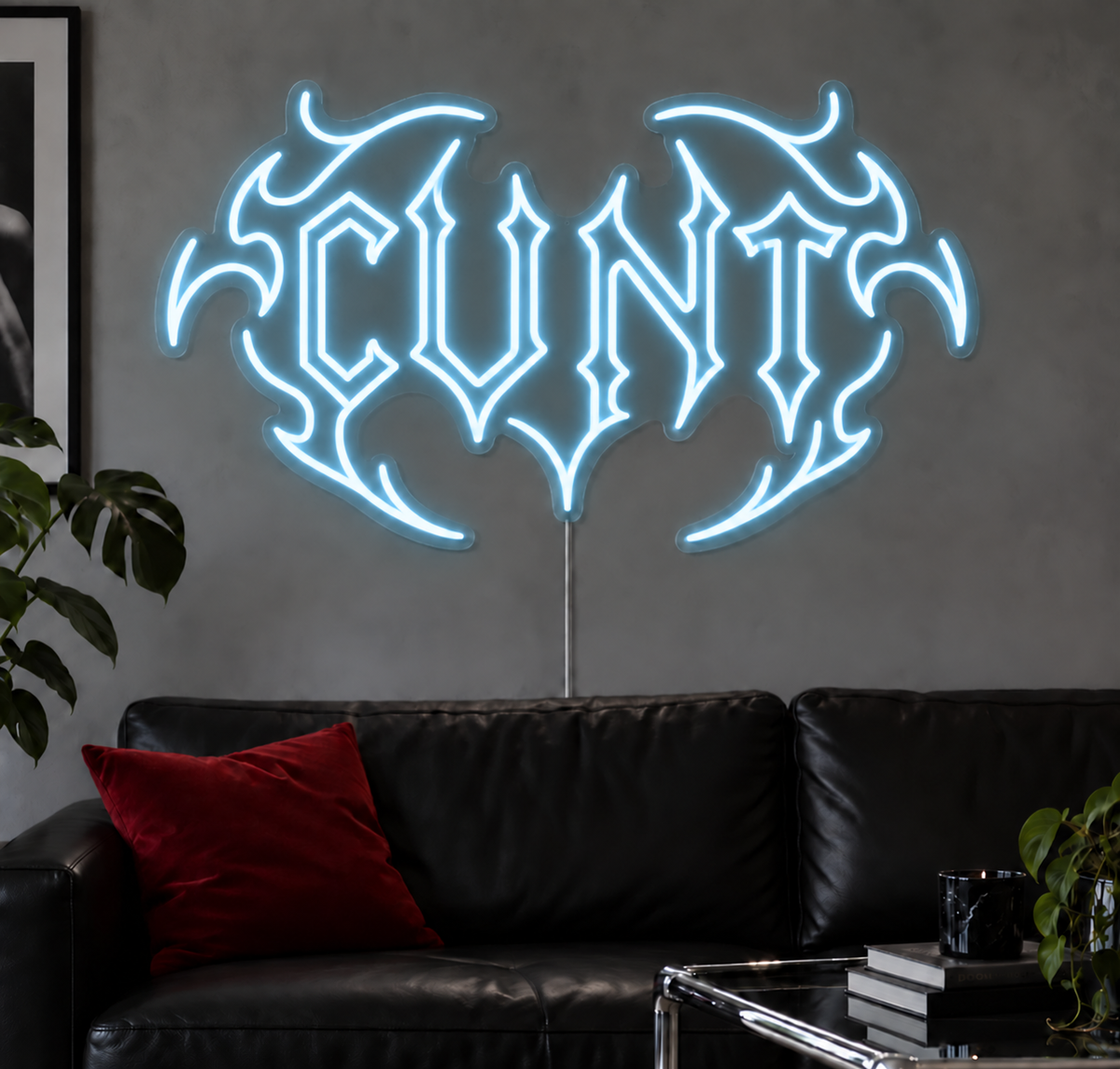 Cunt Neon Sign in Ice Blue LED neon with double outlined C, displayed above a black leather sofa.