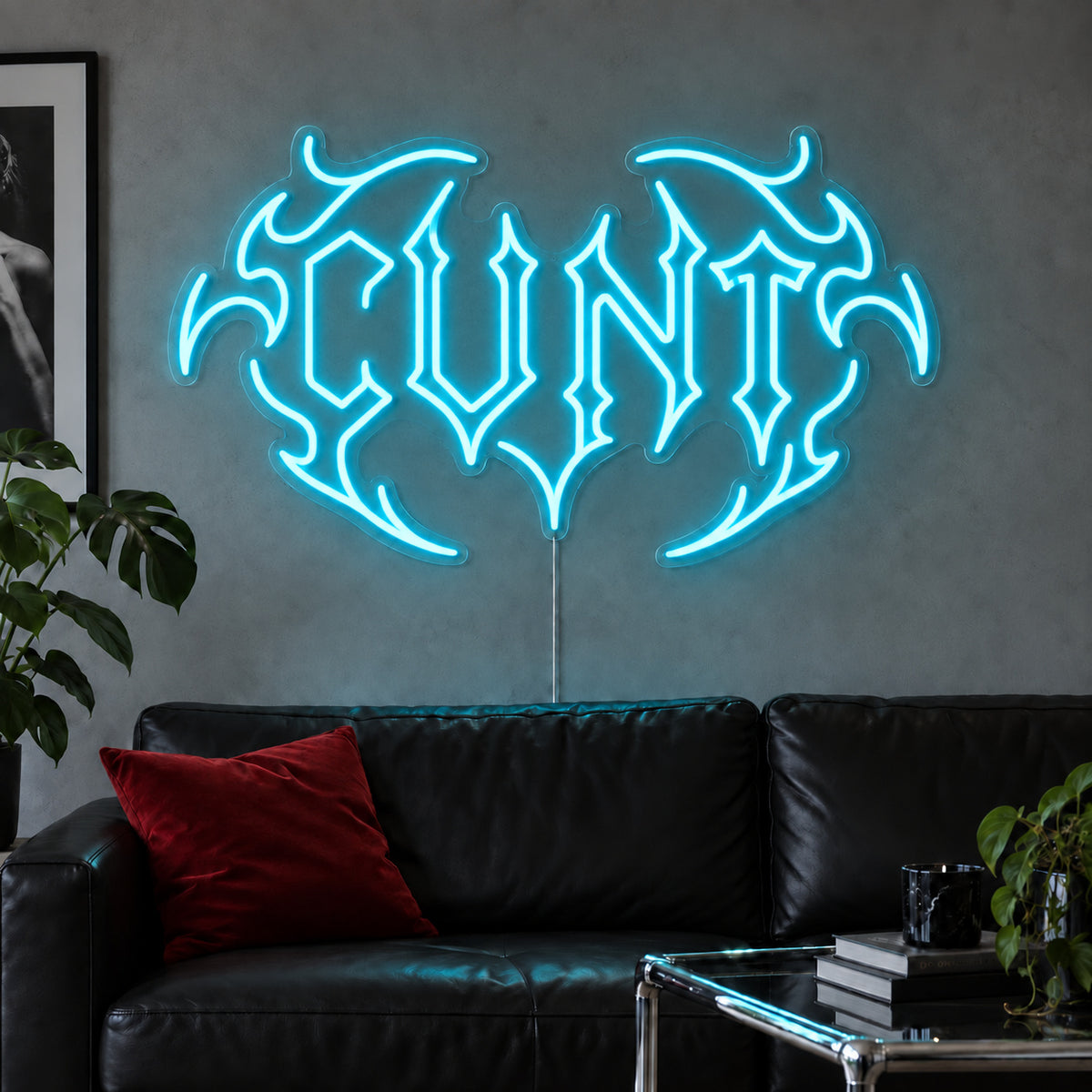 Ice Blue version of the Cunt Neon Sign, shown in a tribal design above a black leather sofa.