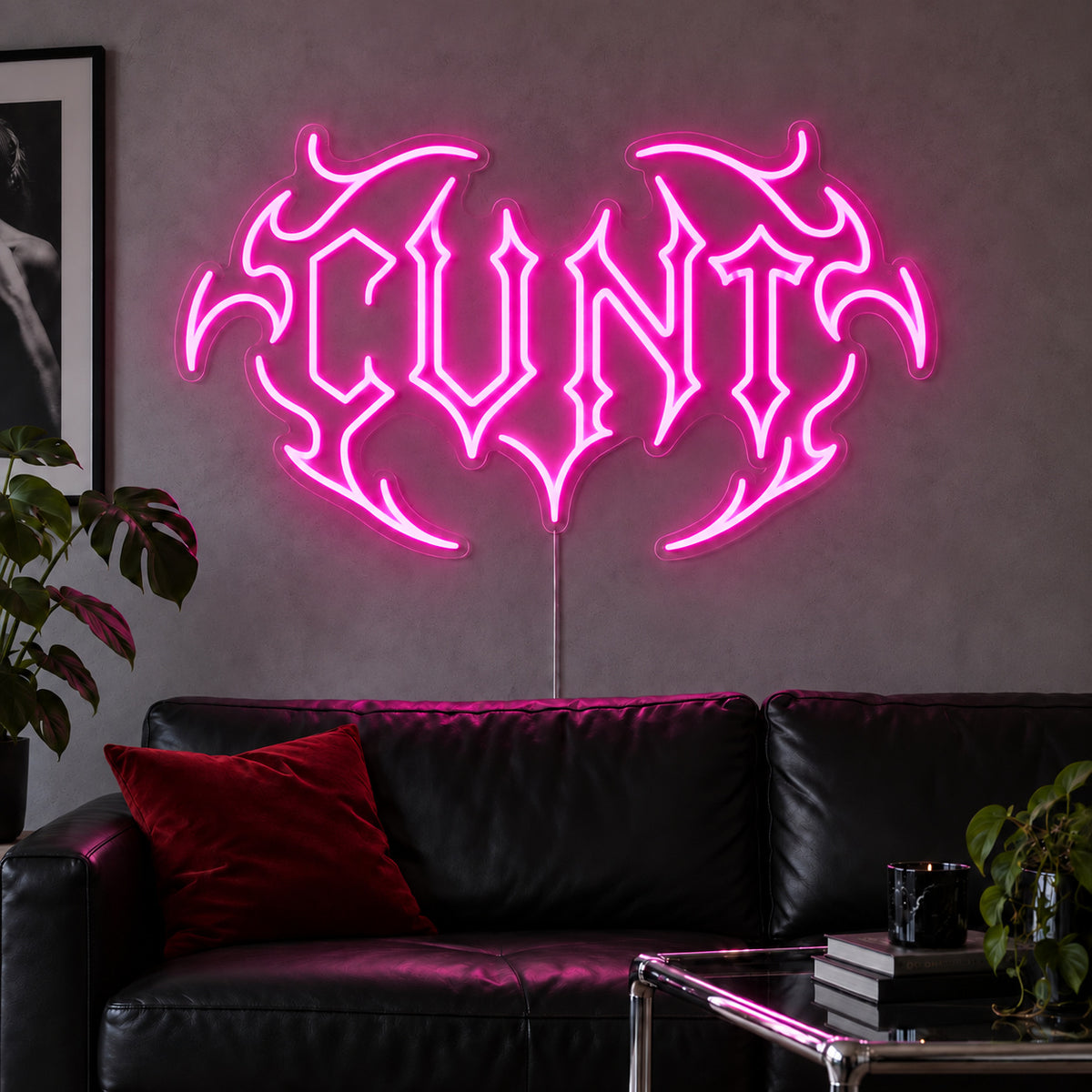 Rose Red version of the Cunt Neon Sign, shown in a tribal design above a black leather sofa.