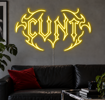 Cunt Neon Sign in Yellow LED neon with double outlined C, displayed above a black leather sofa.