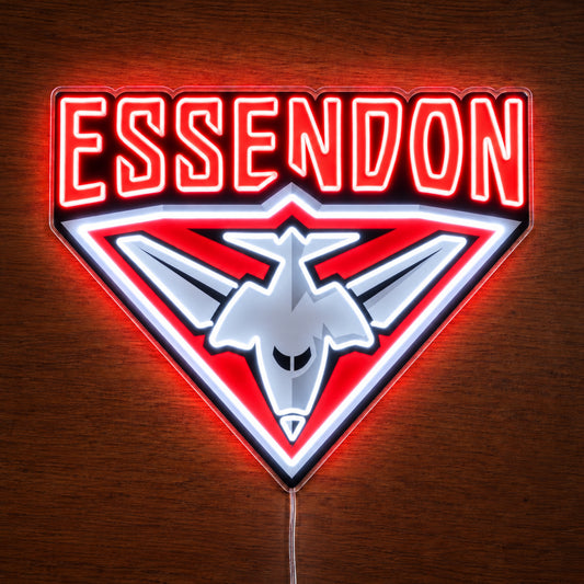 Essendon Bombers neon sign glowing brightly on a wooden surface in dim lighting
