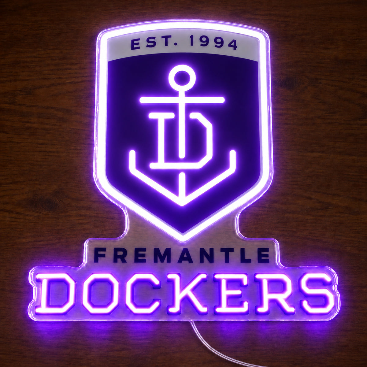 Fremantle Dockers neon sign glowing brightly on a wooden surface in dim lighting