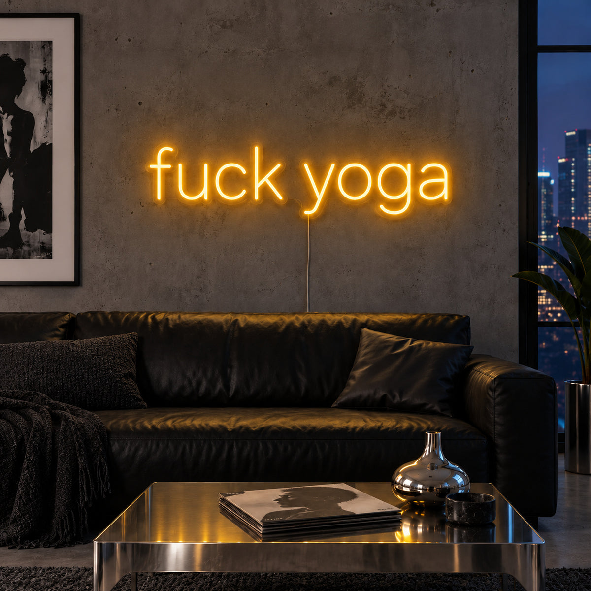 Fuck Yoga Neon Sign glowing gold above a black leather sofa.