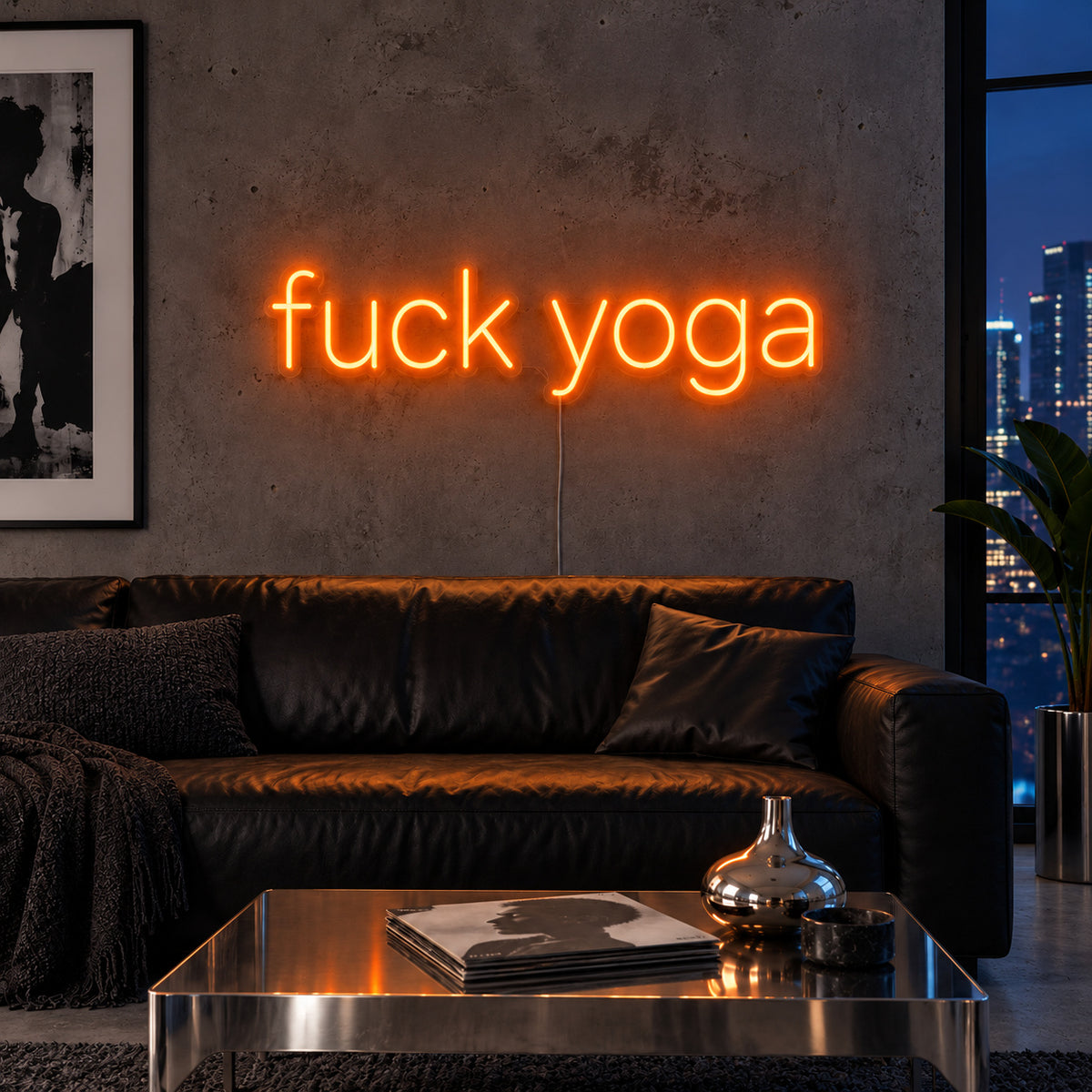 Orange version of the Fuck Yoga Neon Sign, shown above a black leather sofa.