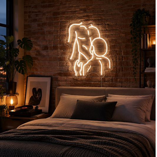Gay Pride Two Men Neon Sign in warm white, featuring an outline of two men kissing on a brick bedroom wall above a bed.