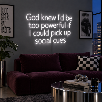 God Knew I'd Be Too Powerful If I Could Pick Up Social Cues Neon Sign, RGB colour-changing option shown in white above a burgundy sofa.