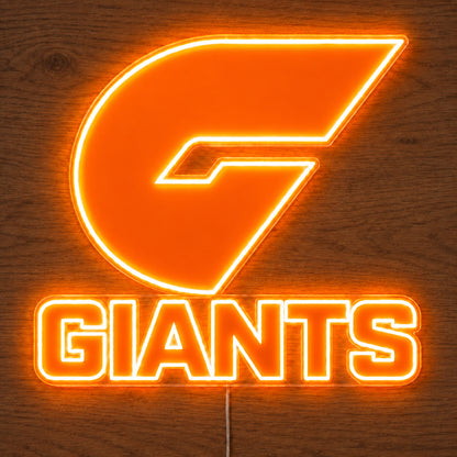 GWS Giants neon sign glowing brightly on a wooden surface in dim lighting