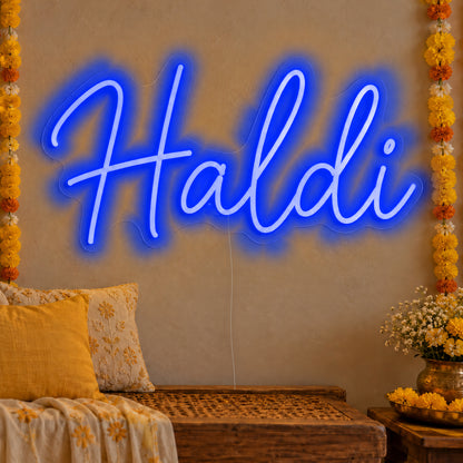 Haldi Neon Sign in blue LED neon on clear acrylic, angled view