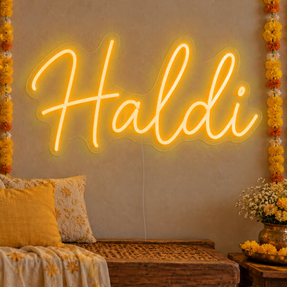 Haldi Neon Sign in gold LED neon on clear acrylic, angled view