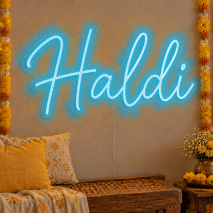 Haldi Neon Sign in ice blue LED neon on clear acrylic, angled view
