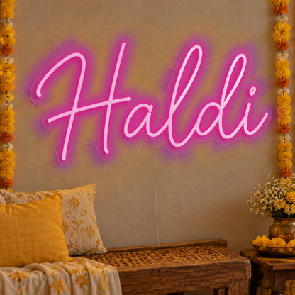 Haldi Neon Sign in pink LED neon on clear acrylic, angled view