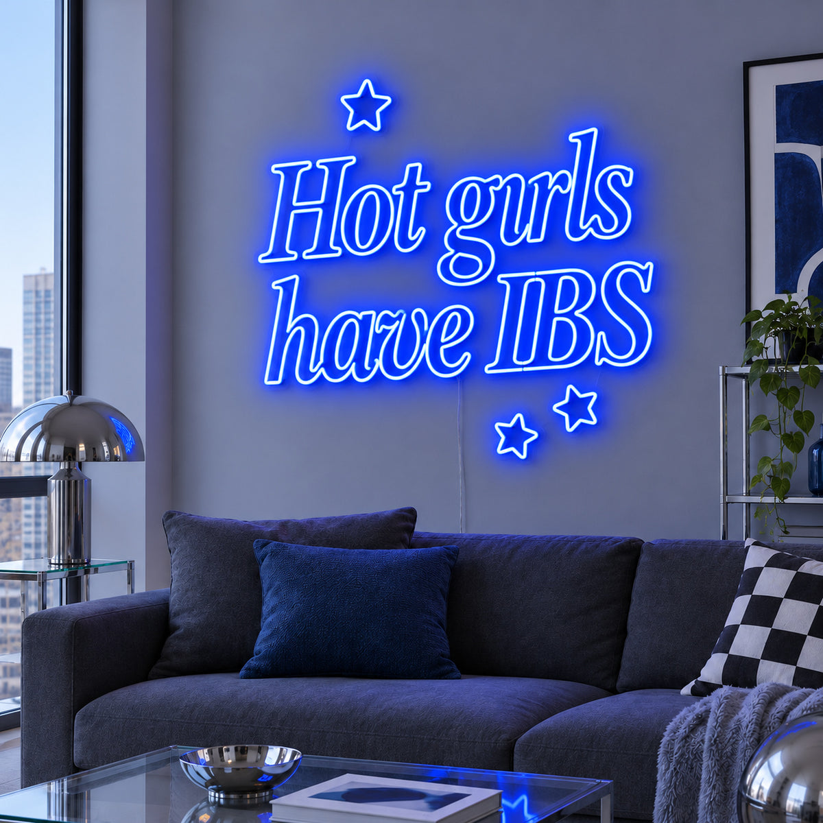 Hot Girls Have IBS Neon Sign glowing blue with star details above a charcoal sofa.