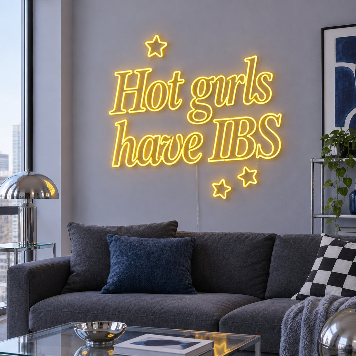 Hot Girls Have IBS Neon Sign in yellow with star details above a charcoal sofa.