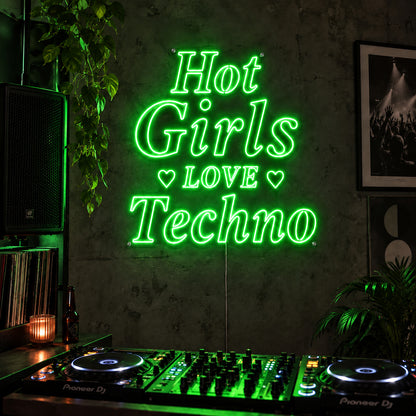 Hot Girls Love Techno Neon Sign with green lighting, displayed with heart details above a DJ setup.