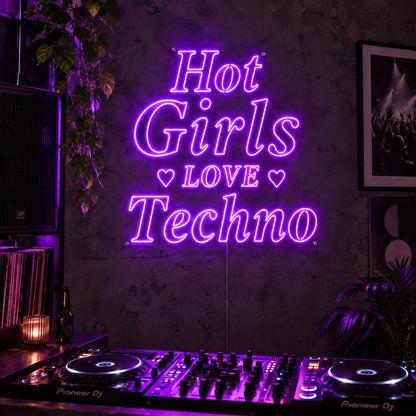 Hot Girls Love Techno Neon Sign with purple lighting, displayed with heart details above a DJ setup.