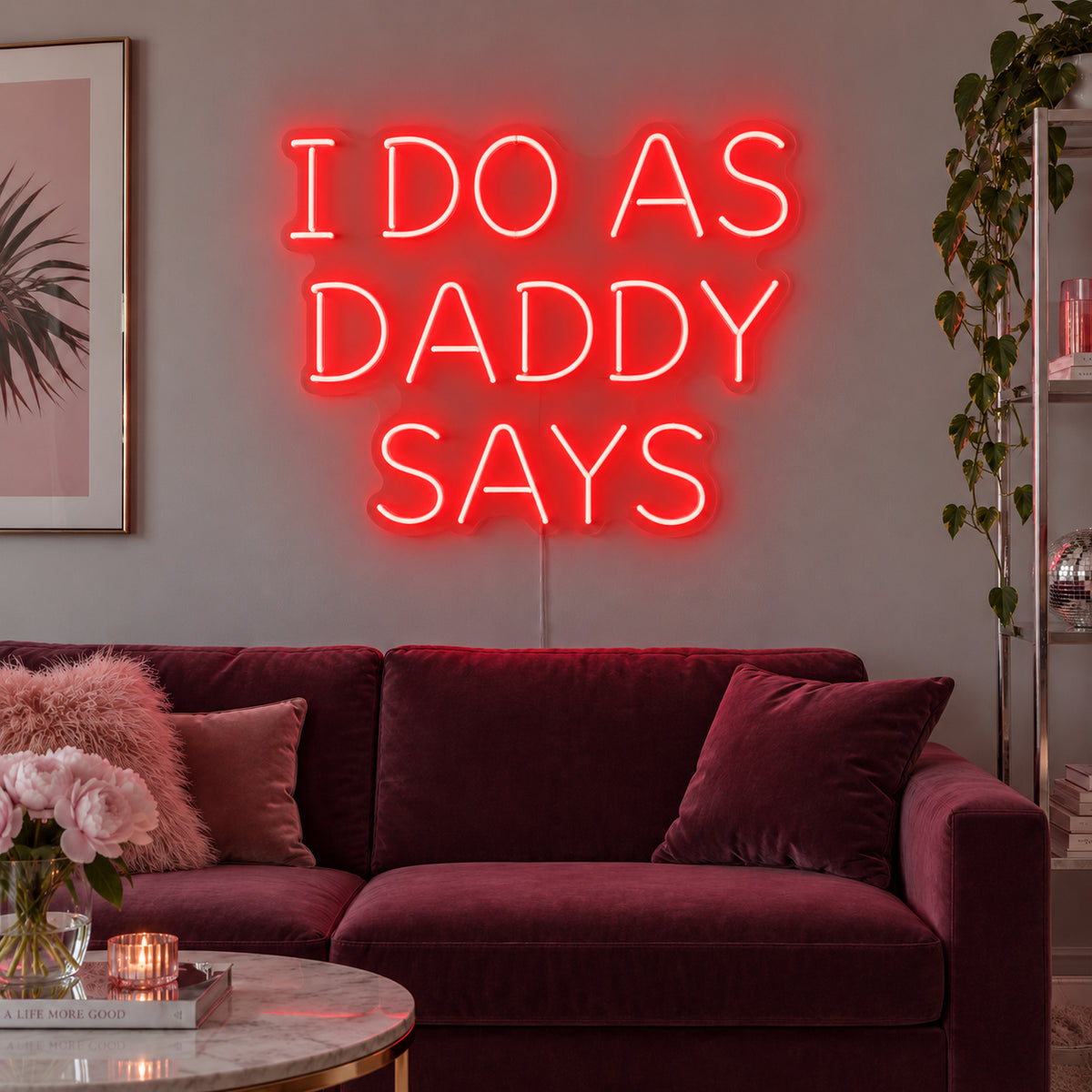 I Do As Daddy Says Neon Sign with red lighting, displayed above a burgundy sofa.