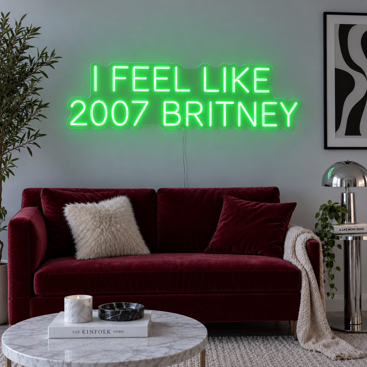 I Feel Like 2007 Britney Neon Sign with green lighting, displayed above a burgundy sofa.