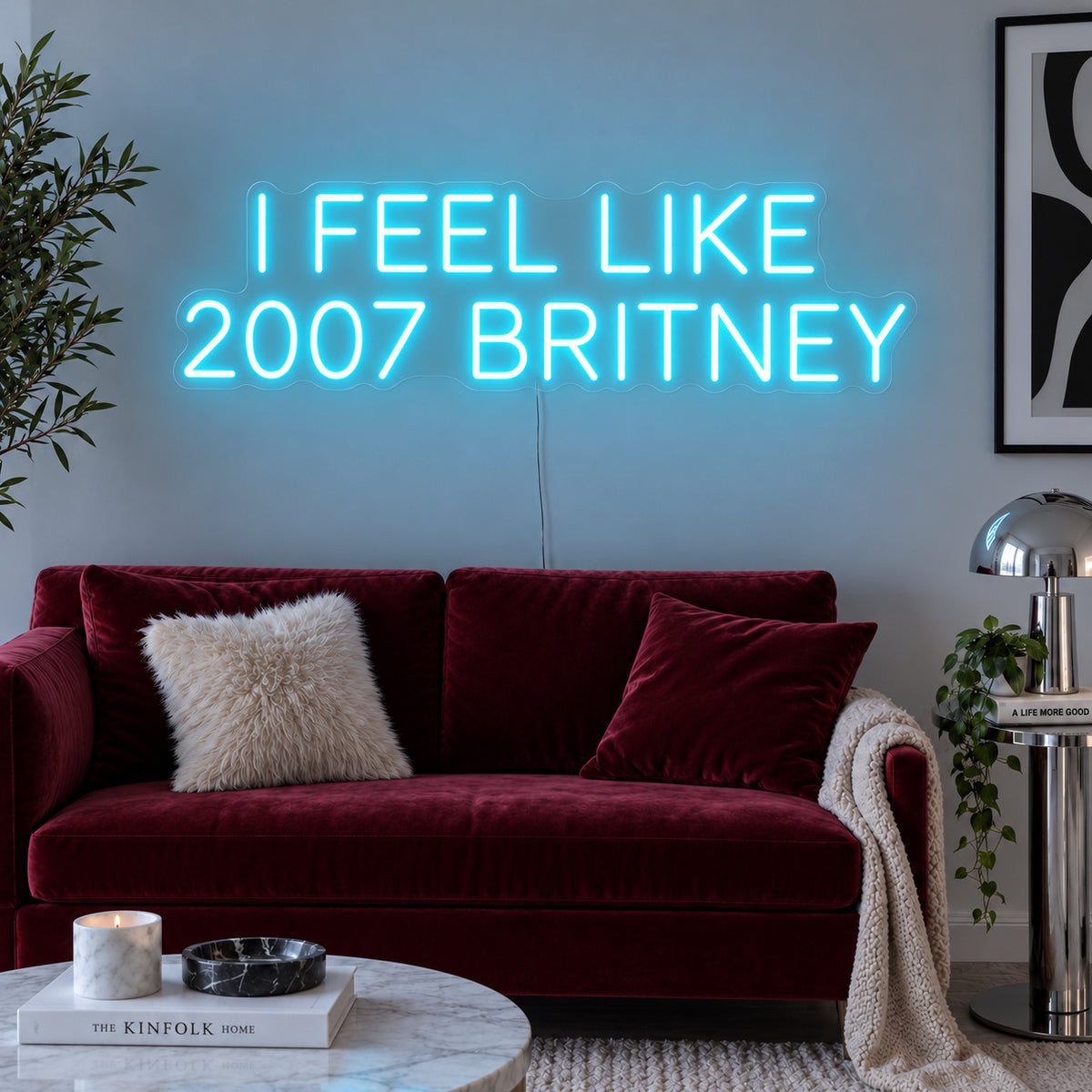 Ice Blue version of the I Feel Like 2007 Britney Neon Sign, shown above a burgundy sofa.