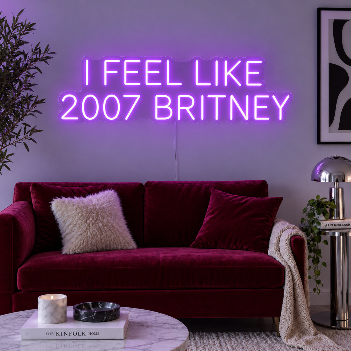 I Feel Like 2007 Britney Neon Sign with purple lighting, displayed above a burgundy sofa.