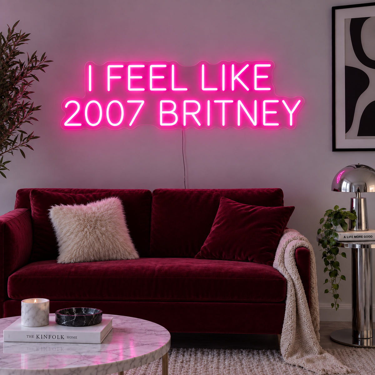 Rose Red version of the I Feel Like 2007 Britney Neon Sign, shown above a burgundy sofa.