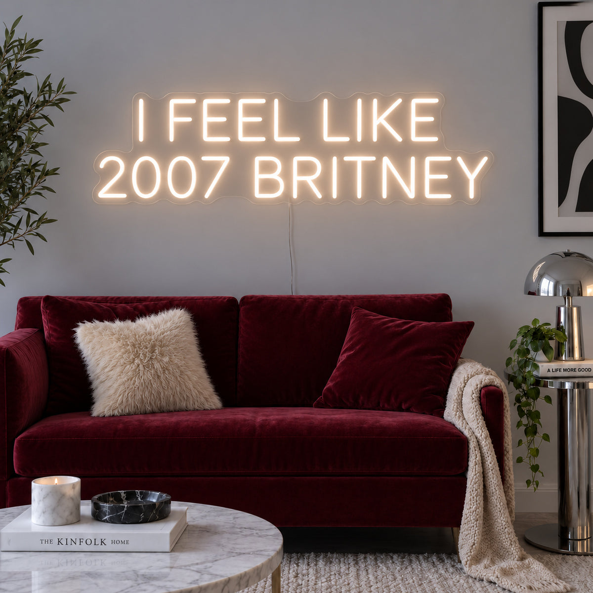 Warm White version of the I Feel Like 2007 Britney Neon Sign, shown above a burgundy sofa.