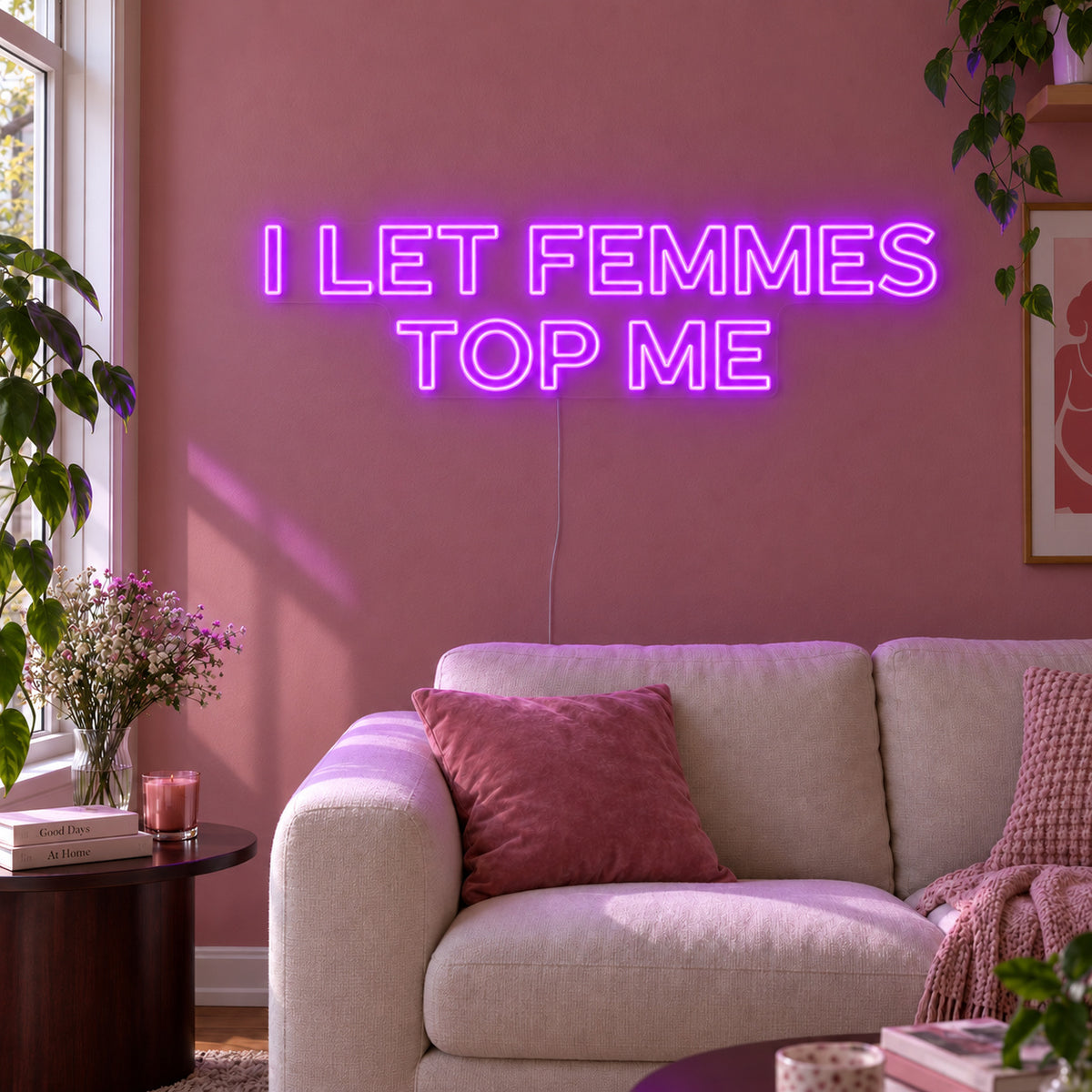 I Let Femmes Top Me Neon Sign with purple lighting, displayed in outlined lettering above a cream chair.