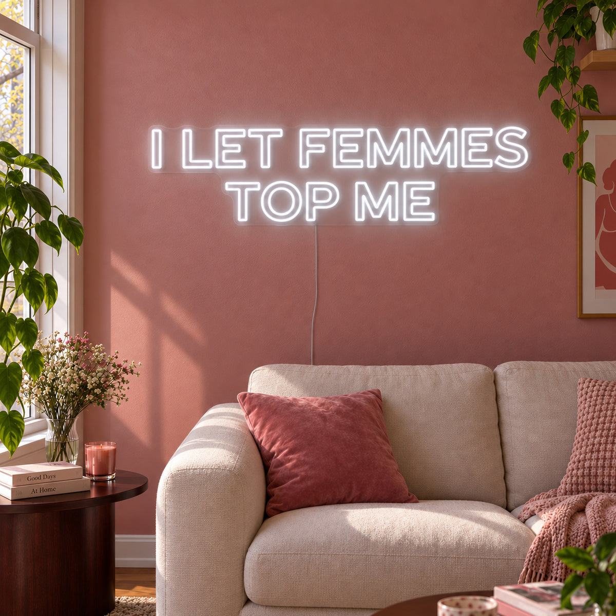 I Let Femmes Top Me Neon Sign, RGB colour-changing option shown in white in outlined lettering above a cream chair.