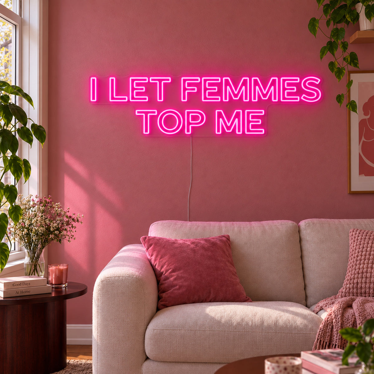 Rose Red version of the I Let Femmes Top Me Neon Sign, shown in outlined lettering above a cream chair.