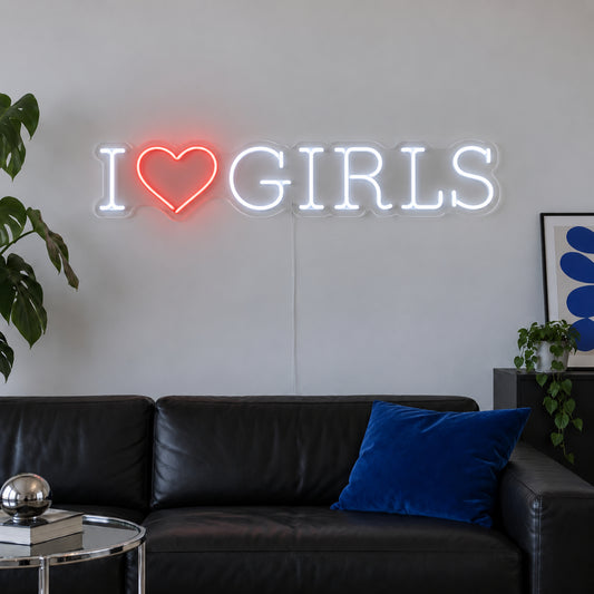 I Love Girls Neon Sign with white lettering with a red heart in a horizontal layout on transparent acrylic, displayed on a living room wall
