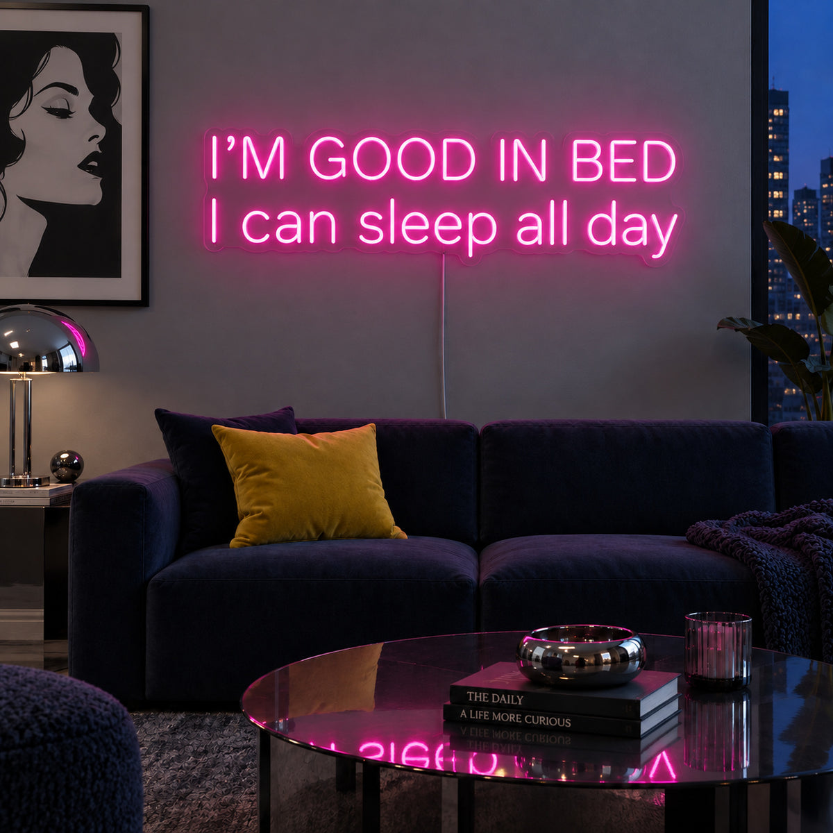 I'm Good In Bed I Can Sleep All Day Neon Sign glowing pink above a navy sofa.