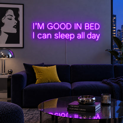 I'm Good In Bed I Can Sleep All Day Neon Sign with purple lighting, displayed above a navy sofa.
