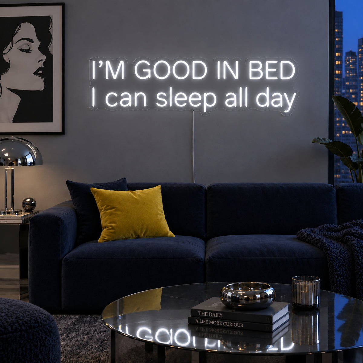 I'm Good In Bed I Can Sleep All Day Neon Sign glowing white above a navy sofa.