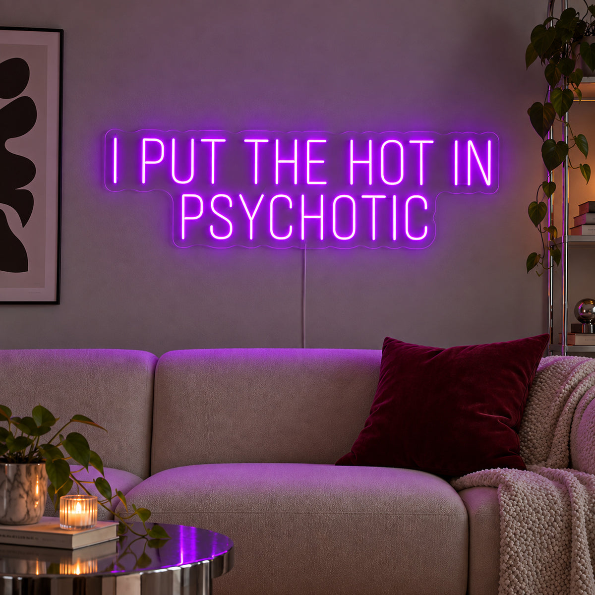 I Put The Hot In Psychotic Neon Sign with purple lighting, displayed above a neutral sofa.