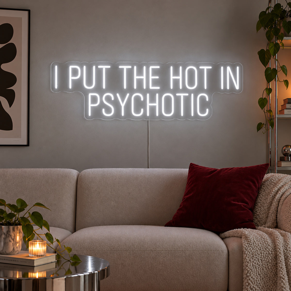 I Put The Hot In Psychotic Neon Sign, RGB colour-changing option shown in white above a neutral sofa.