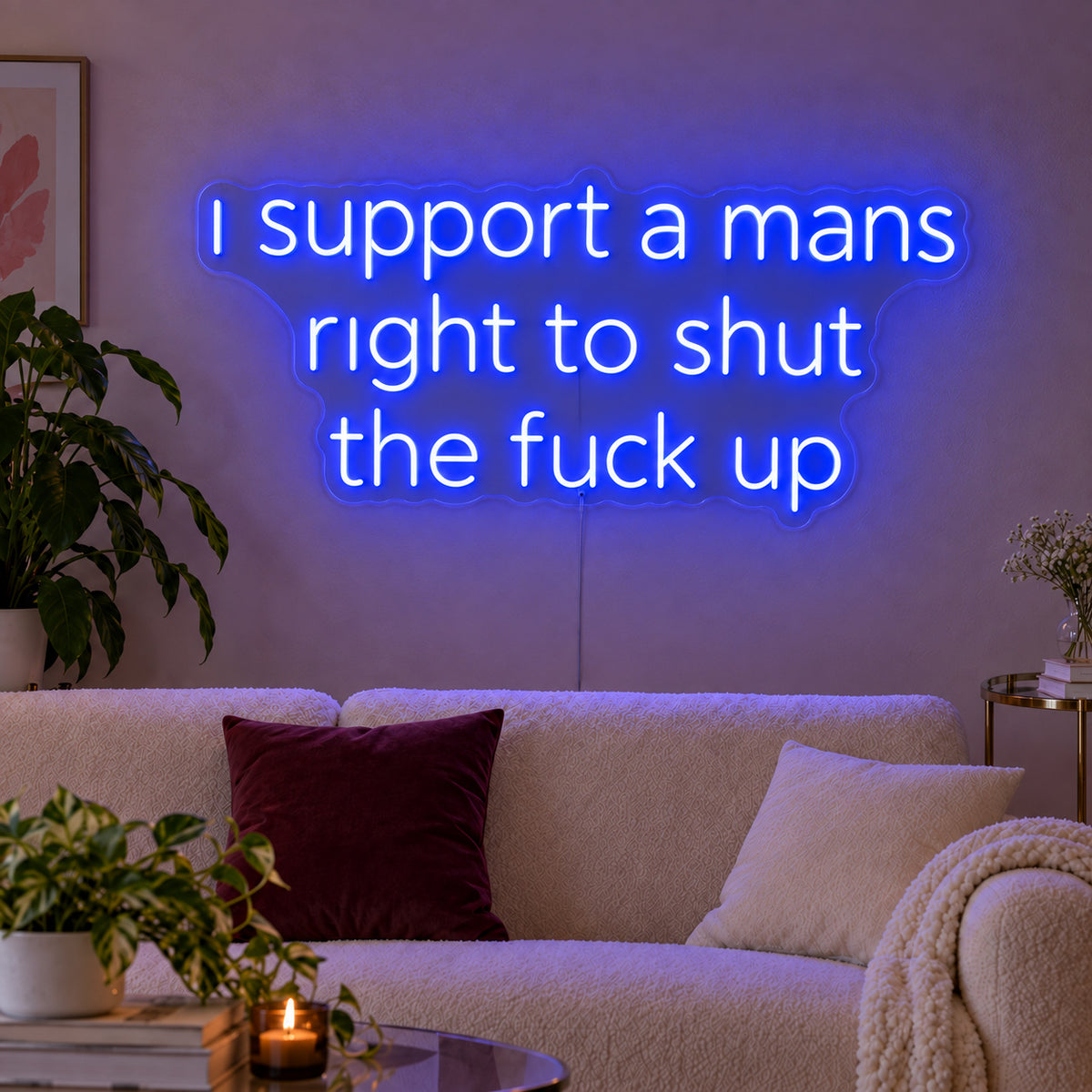 I Support A Mans Right To Shut The Fuck Up Neon Sign glowing blue above a cream sofa.