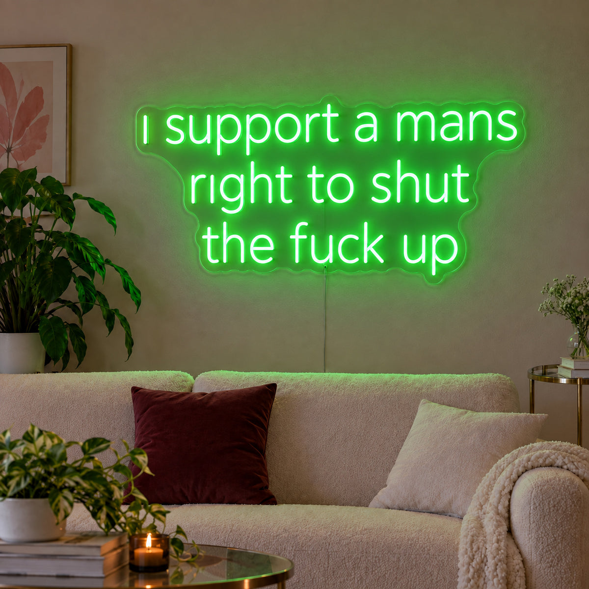 I Support A Mans Right To Shut The Fuck Up Neon Sign with green lighting, displayed above a cream sofa.