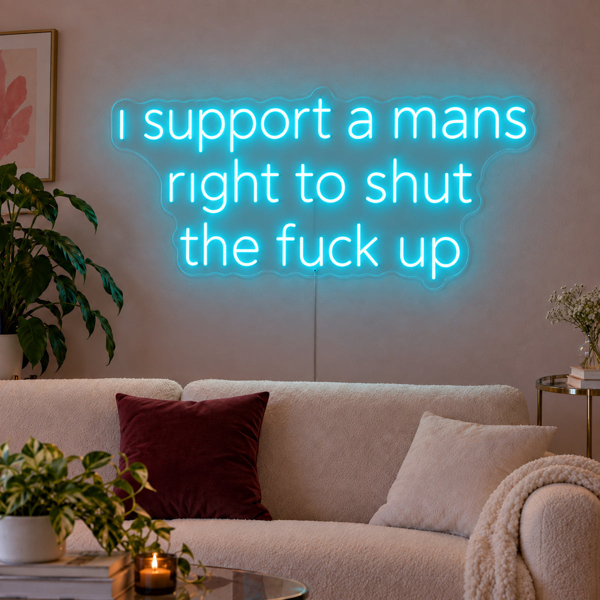 Ice Blue version of the I Support A Mans Right To Shut The Fuck Up Neon Sign, shown above a cream sofa.