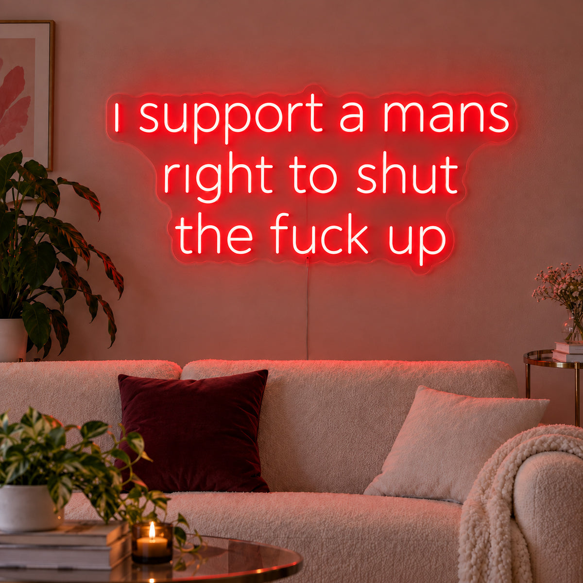 I Support A Mans Right To Shut The Fuck Up Neon Sign with red lighting, displayed above a cream sofa.