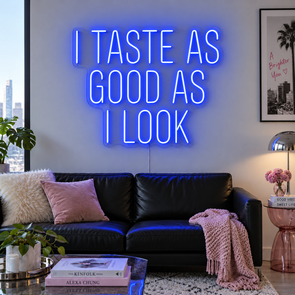 I Taste As Good As I Look Neon Sign glowing blue above a black sofa.